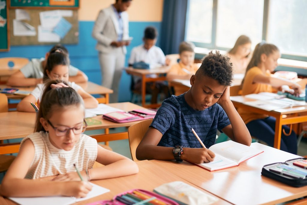 Elementary students writing dictation during class in the classroom.