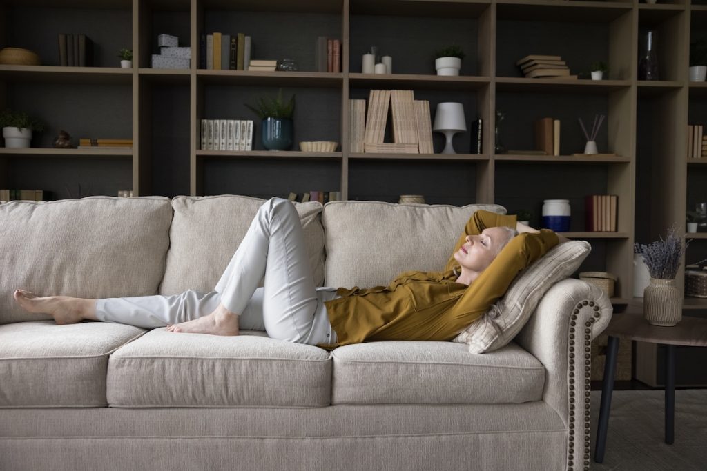 Peaceful calm mature woman lying on sofa with closed eyes Peaceful calm mature woman lying on sofa with closed eyes, sleeping, stretching body, enjoying break, silent leisure time at home, taking deep breath of fresh air, relaxing, reducing stress