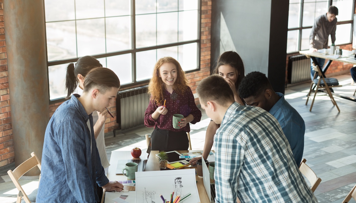 Happy work time. Group of multiethnic designers brainstorming in loft office, discussing project plan, copy space